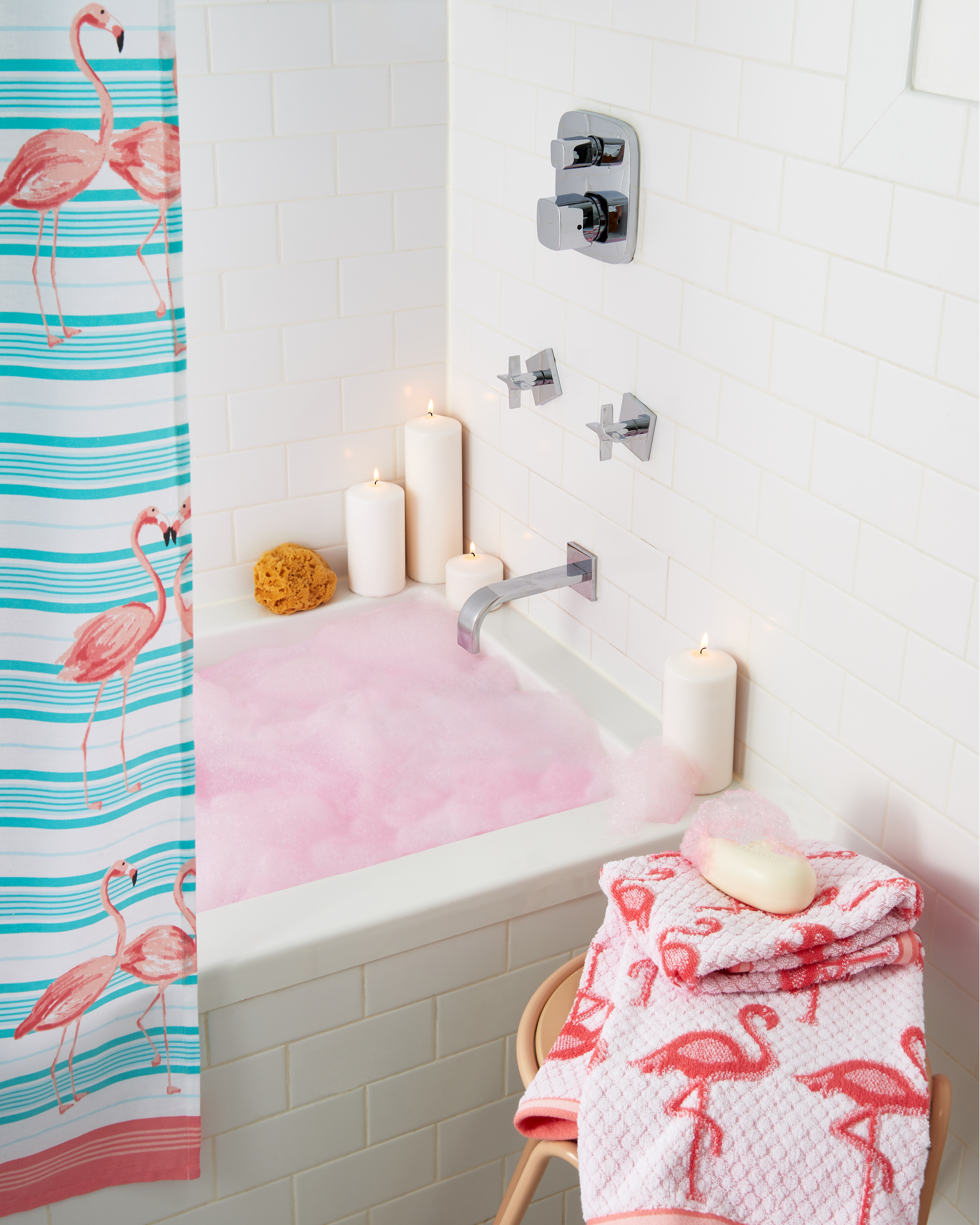 Bubble bath with pink bubbles and bright colored candles and towels  Still-life by Alison Gootee Photography