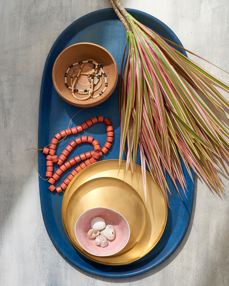 Table top with saw palmetto gold bowls coral beads in sunny  Still-life by Alison Gootee Photography