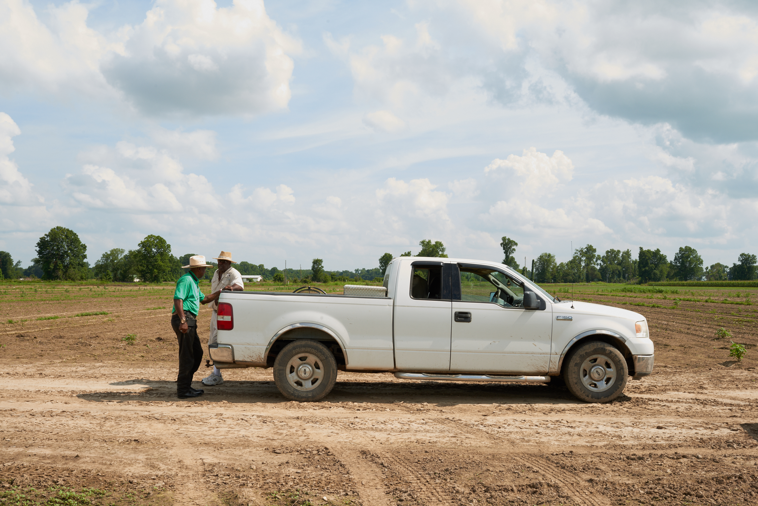 Black Farmers standing by pick up truck by Alison Gootee Photography