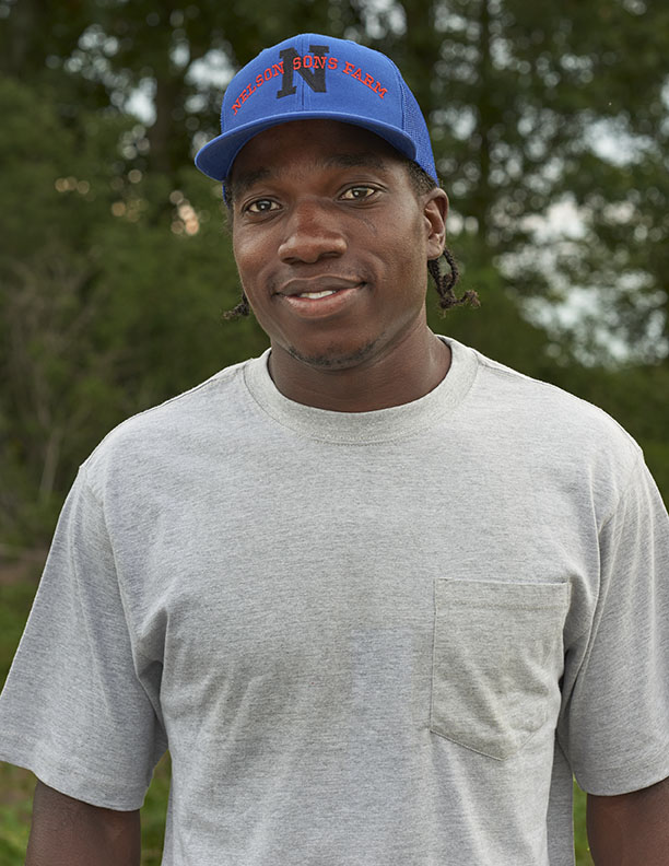 Black Farmer smiling with blue baseball cap by Alison Gootee Photography