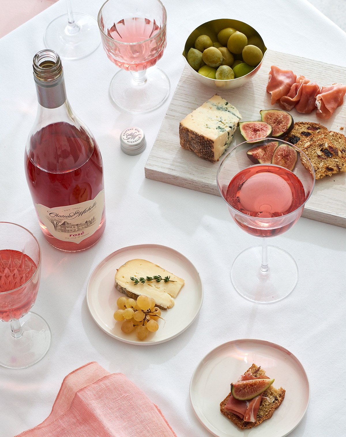 Bottle of Rose wine with charcuterie and small plates is food photography by Alison Gootee Photography