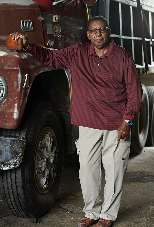 Black Farmer standing by truck by Alison Gootee Photography