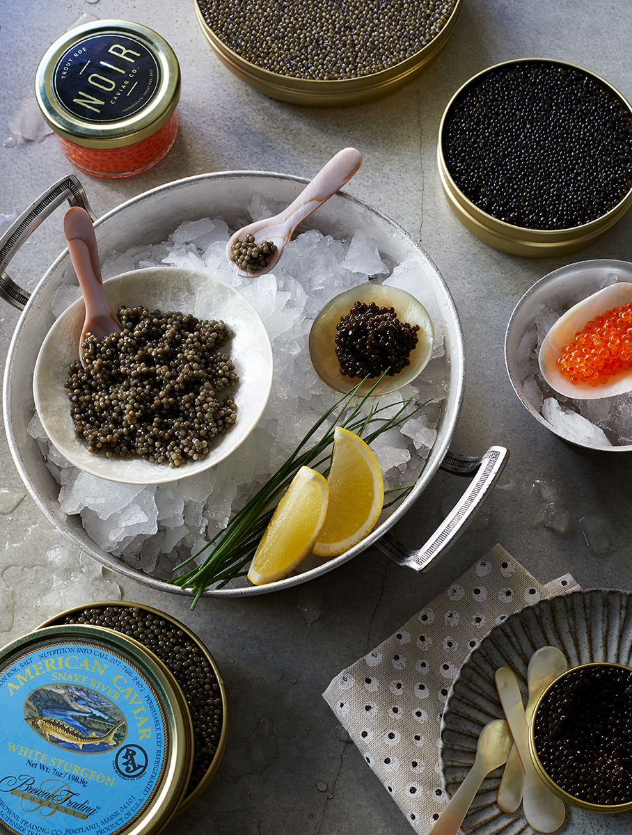 Selection of tinned caviar on ice  with blinis is food photography by Alison Gootee Photography
