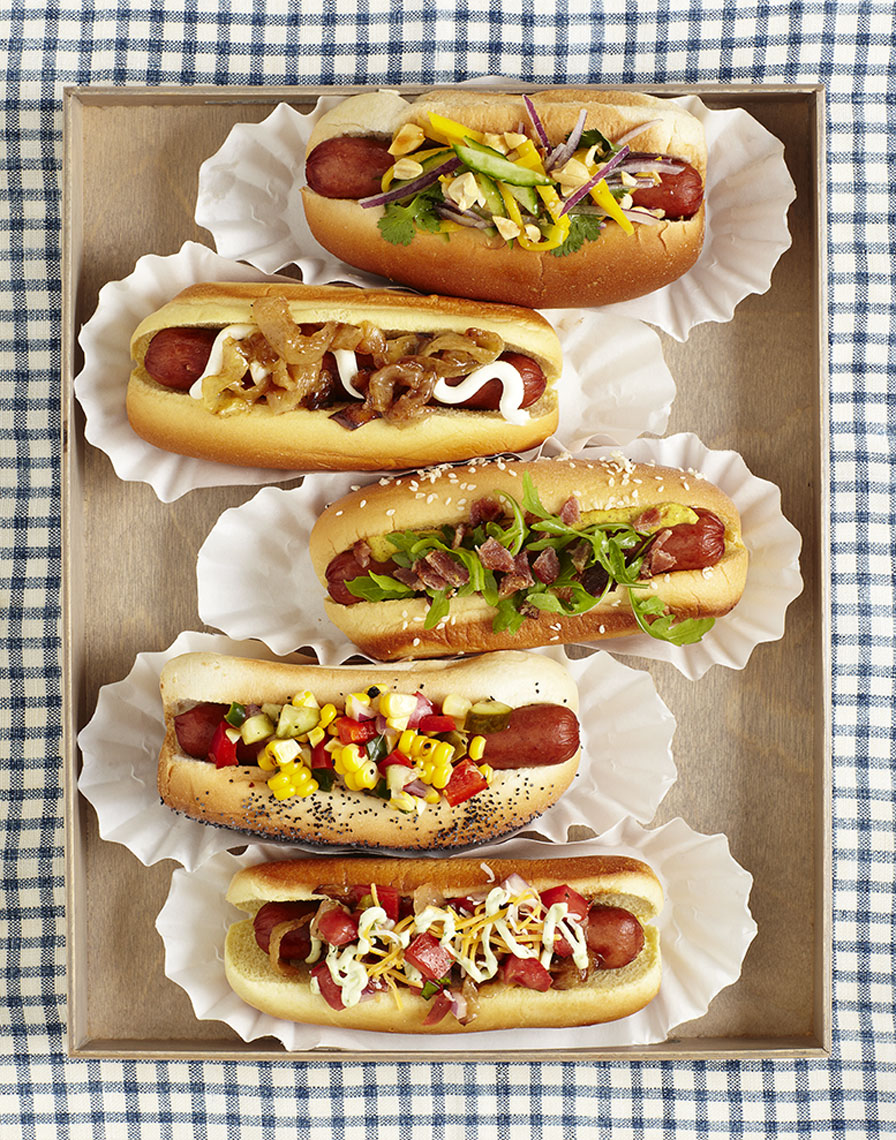 Four garnished hot dogs in buns in a tray is food photography by Alison Gootee Photography