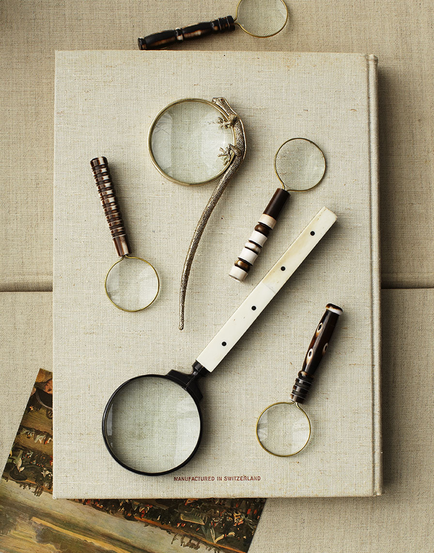 Group of magnifying glasses on linen covered book  Still-life by Alison Gootee Photography