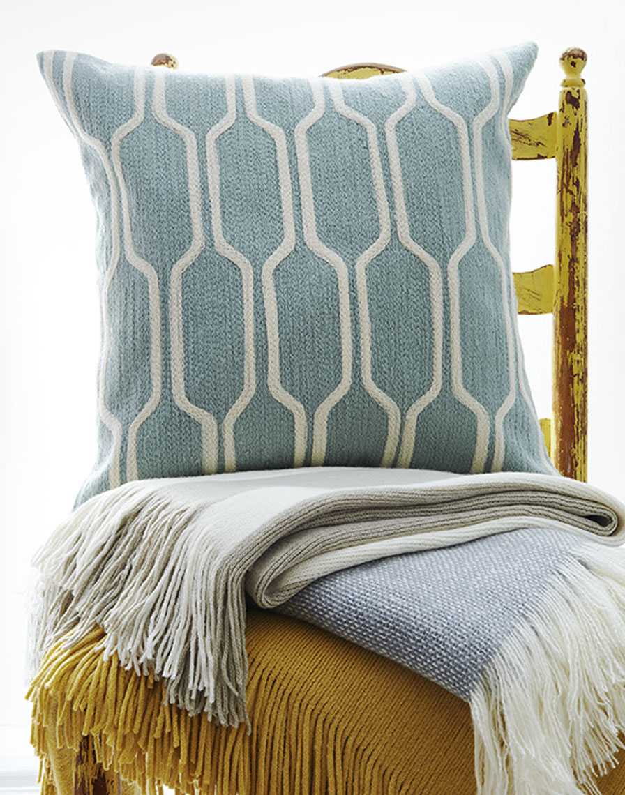 Stack of throw and a blue pillow on a chair Still-life by Alison Gootee Photography