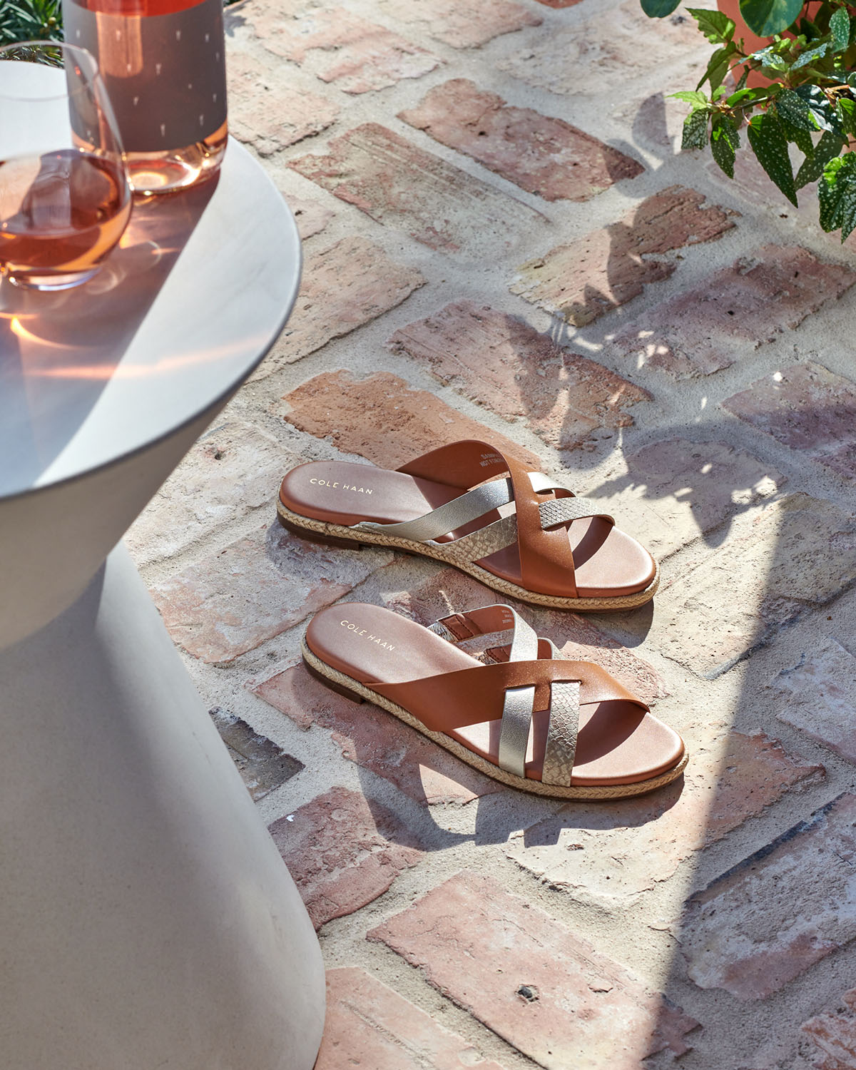 Sandals on brick porch in sunlight  by  Alison Gootee Photography