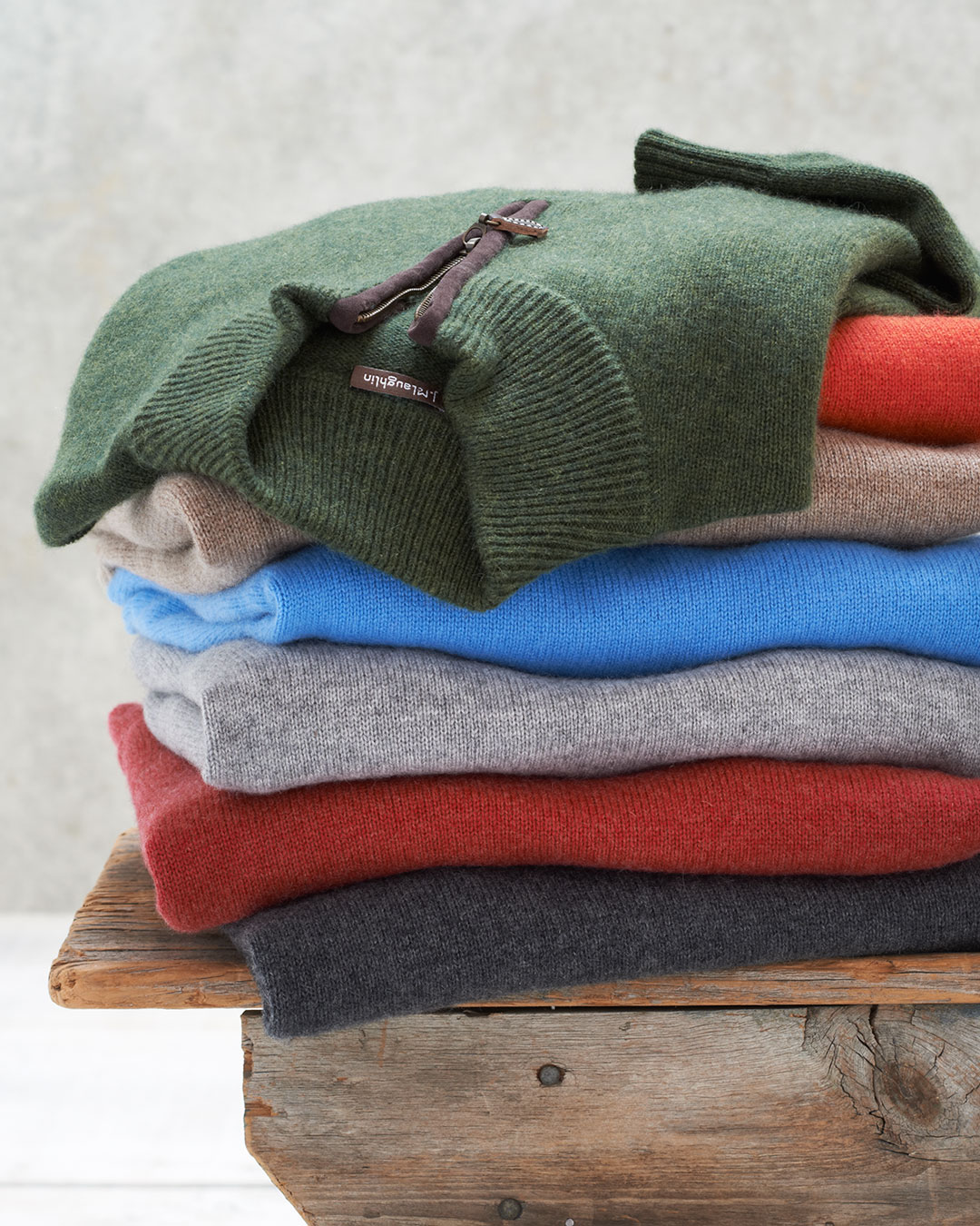 Stack of sweaters on a bench by Alison Gootee Photography 